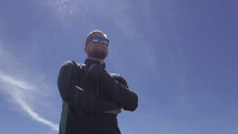 Man-standing-proudly-confirming-affirming-low-angle-sky-circling,-Rockies-Kananaskis-Alberta-Canada