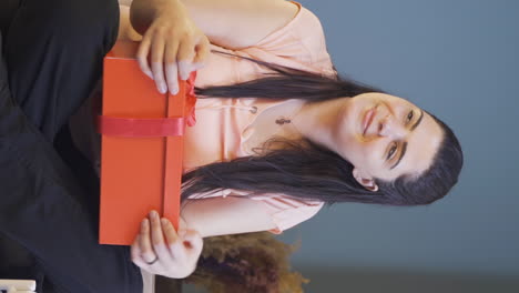 vertical video of woman waiting for someone with gift box.