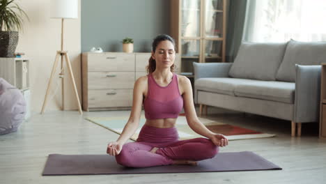 una mujer joven meditando en la postura del loto.