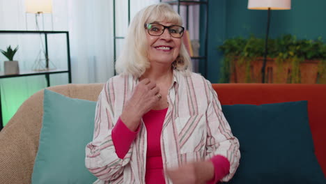 Portrait-of-happy-caucasian-senior-old-grandmother-in-casual-shirt-smiling-looking-at-camera-at-home