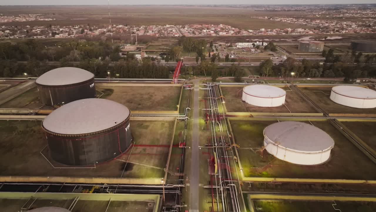 Moving aerial view showing the crude oil storage complex and industrial tanks as the drone zooms out