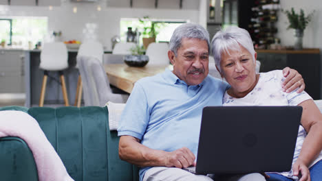 Feliz-Pareja-Birracial-Senior-Riendo-Y-Usando-Tableta