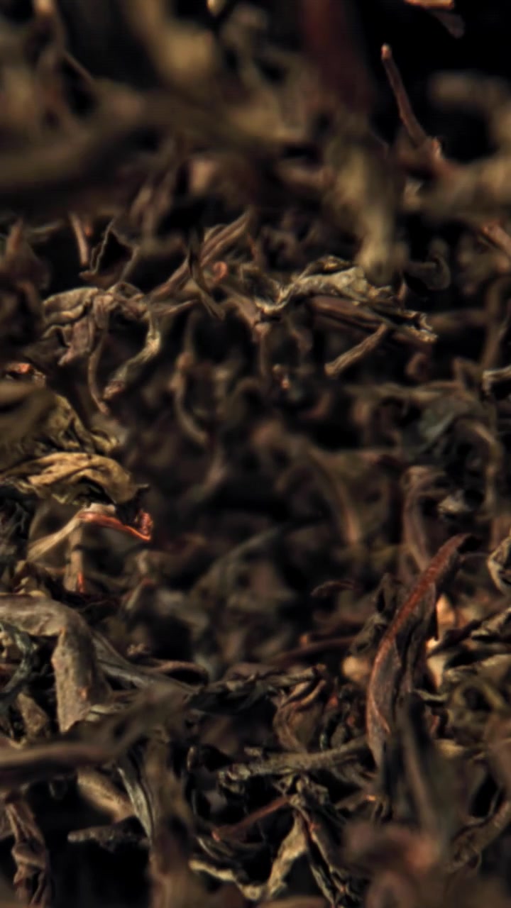 Macro Shot of Dried Black Tea Leaves Falling in Slow Motion