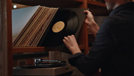 person selecting a vinyl record from a collection