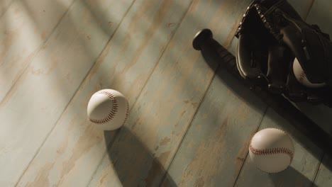 overhead studio baseball still life with bat ball and catchers mitt on aged wooden floor 2