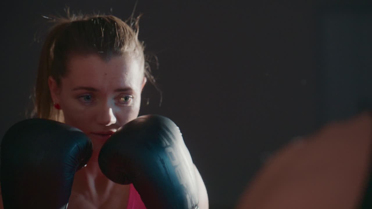 Determined Woman Practicing Boxing Punches with a Trainer