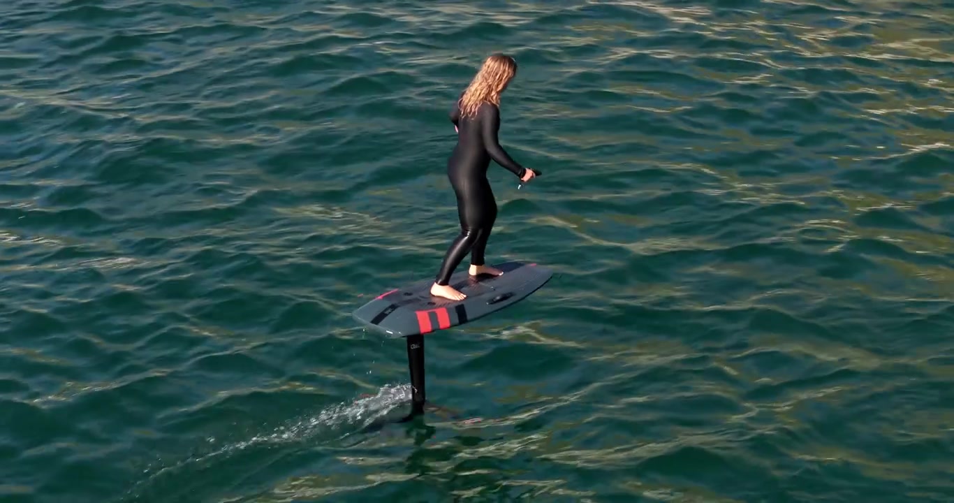 Donna che guida una tavola idrofoglio elettrica sull'oceano