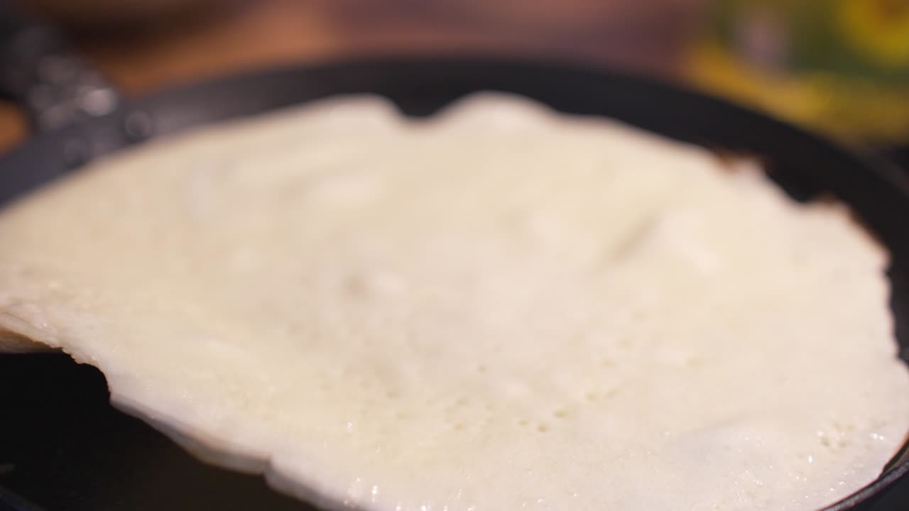 Close-up of a pancake cooking on a hot pan