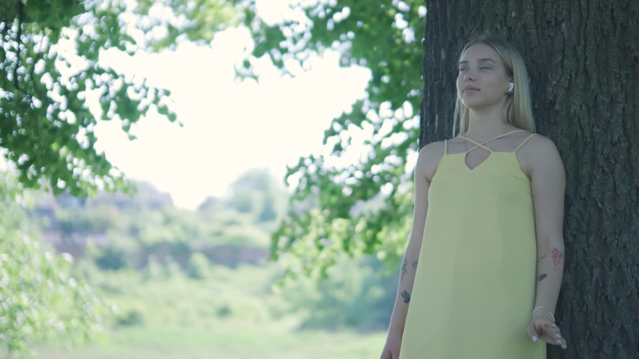 여름 공원에서 나무 에서 춤을 추는 노란색 드레스를 입은 여자