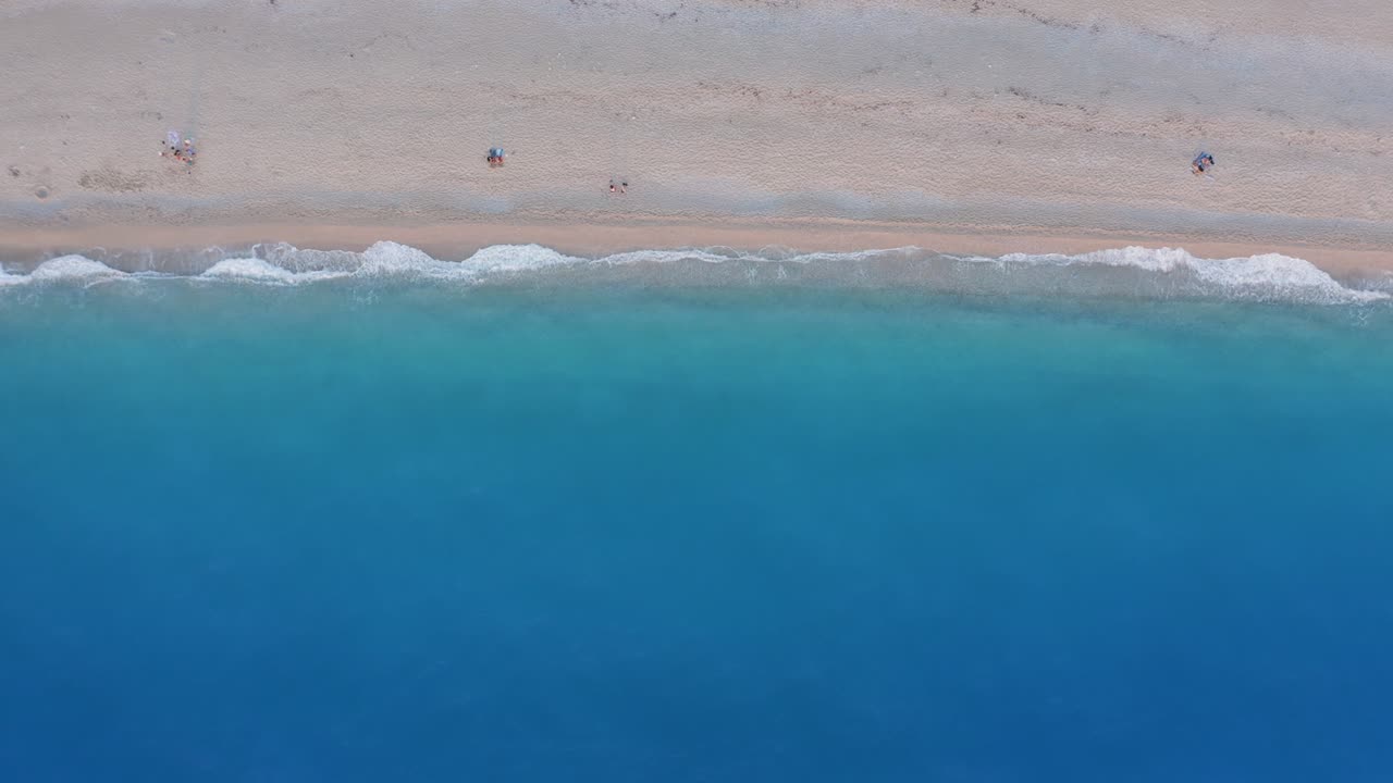 미로스 해변, 레프카다, 그리스 황금 모래와 형광, 르키즈 바다 파도의 위에서 아래로 볼 수 있습니다. 해가 지는 동안 여름 장면을 즐기는 인식 할 수없는 사람들.