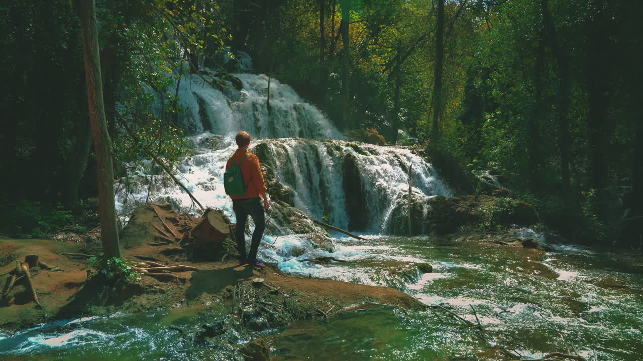 hermosa cinemagrafía 4k uhd de cascadas en el parque nacional krka en croacia a principios de verano con un joven