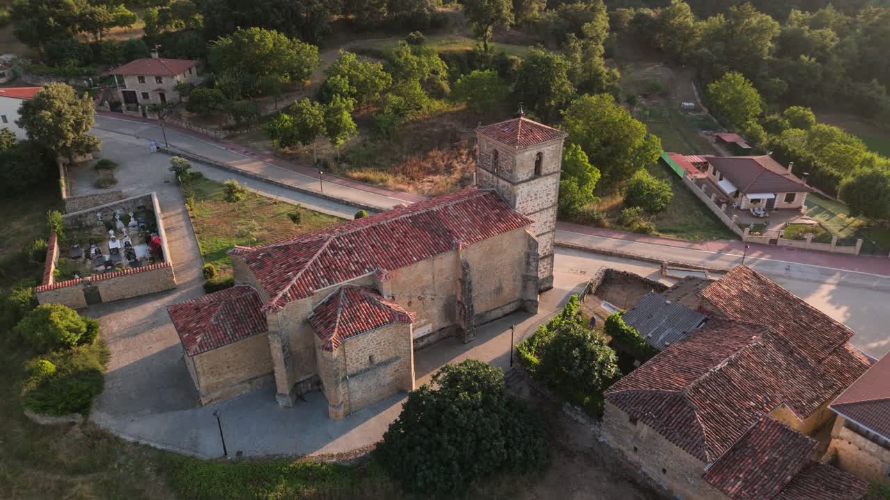 Orbital drone shot showing a local church in a village in the countryside of Valderama in Castille and Leon, Spain.