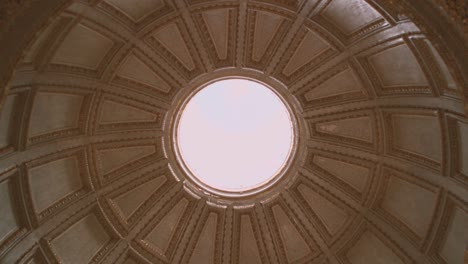 Dome-of-a-church-in-Nazare-seen-from-inside,-intrados,-circular-base,-with-central-hole-and-view-of-the-sky,-in-Portugal,-Extremadura