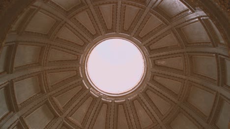 Dome of a church in Nazare seen from inside, intrados, circular base, with central hole and view of the sky, in Portugal, Extremadura