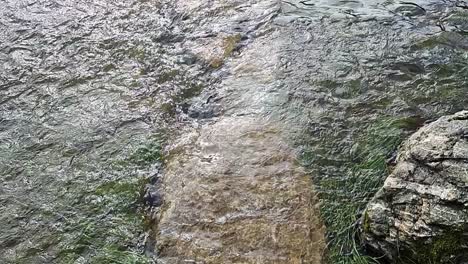 slow motion saturated flooded countryside stream burst its banks with submerged stone pathway underwater after storm weather