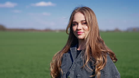 beautiful blonde walks outdoors. portrait of attractive young model with long hair on blur nature background. slow motion.