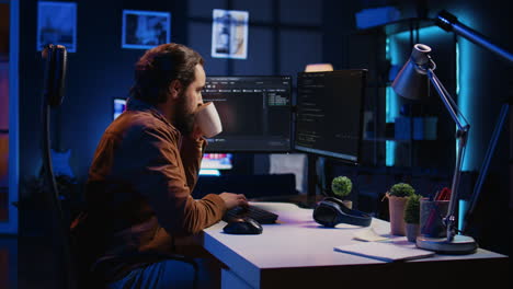 computer scientist drinking cup of coffee while developing code on pc