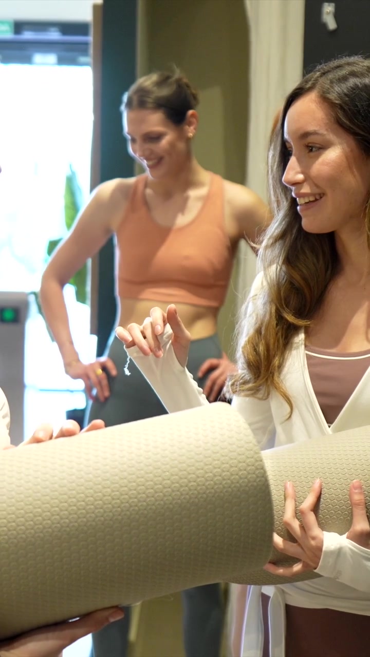 Happy Woman Holding Yoga Mat and Talking with Friends