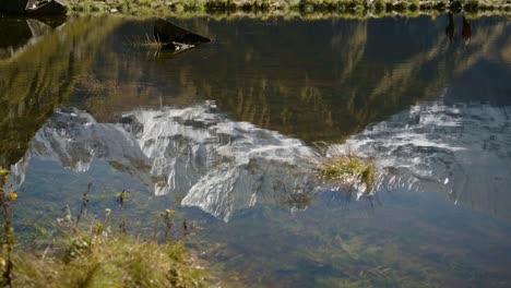 snowcapped mountains reflection close up, high altitude lake reflecting himalayas mountains in calm still water on popular trekking and hiking route of annapurna circuit in nepal