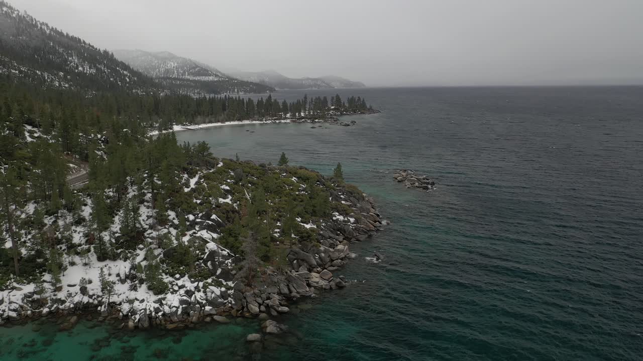 toma aérea de paralaje de la costa del lago tahoe en un día de niebla de invierno