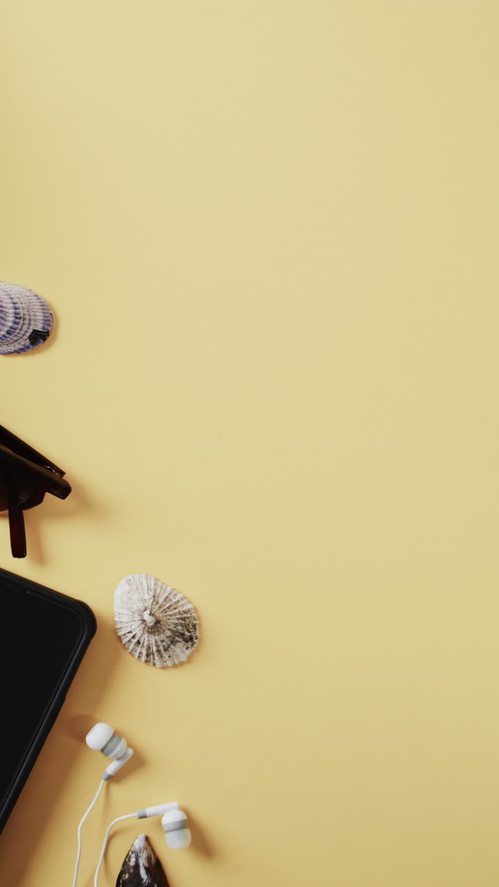 Close up of white airplane model, shells, sunglasses, smartphone and copy space on yellow background