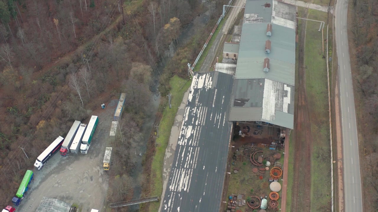drone overlooking an abandon factory overlooking some riuns n train tracks from top botton around a river