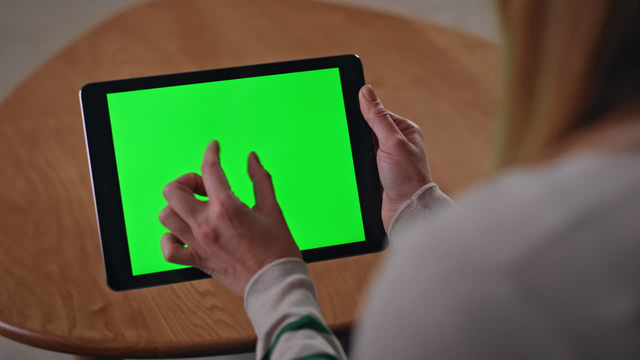 Online customer zooming chroma key tablet shopping remotely at home close up.