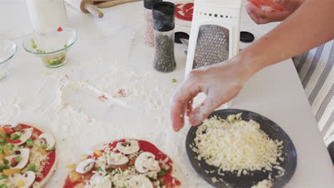 las manos preparan las coberturas de la pizza en una cocina casera