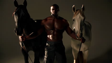 Muscular Man Posing Confidently with Two Horses