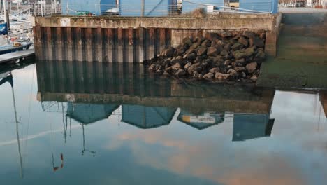 reflections of buildings in port at sunrise