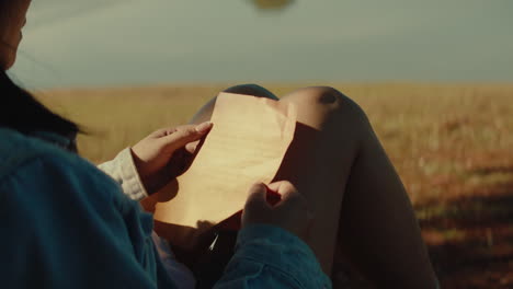 woman reading an old letter outdoors