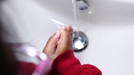 girl washing hands with soap and water