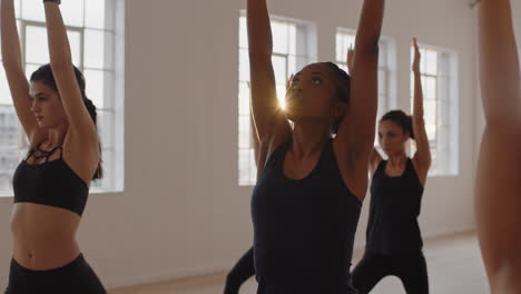 Clase-De-Yoga-Grupo-De-Mujeres-Multirraciales-Practicando-Pose-Guerrera-Disfrutando-De-Un-Estilo-De-Vida-Saludable-Haciendo-Ejercicio-En-El-Gimnasio-Instructor-Enseñando-Meditación-Grupal-Al-Amanecer