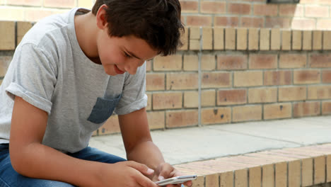 Happy-schoolboy-using-mobile-phone