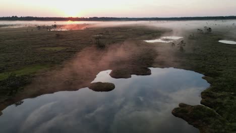 Low-flyover-of-lowland-bog-with-fiery-fog-during-cool-morning-sunrise