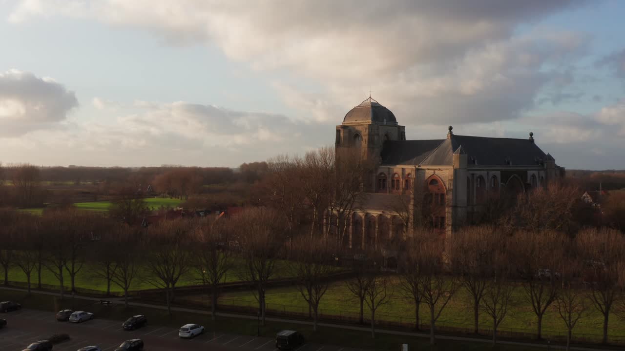 Revealing shot of the big Church of Veere from the canal. Slow drone shot from low to high angle