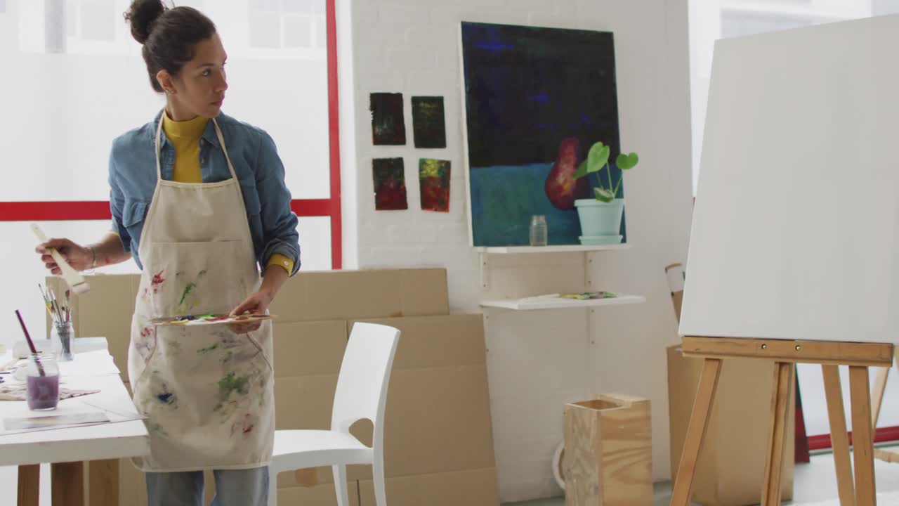 Video di un'artista donna birazziale che dipinge in studio