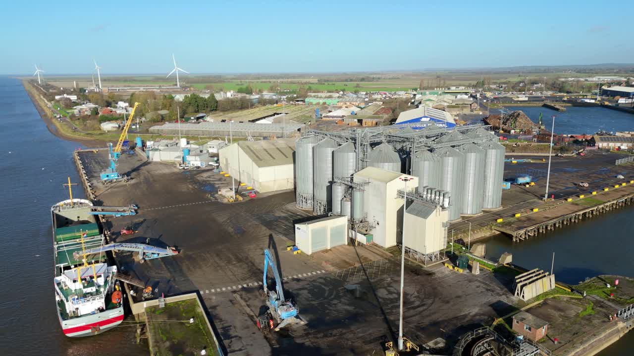 Luftaufnahme aus großer Höhe der Hafeninfrastruktur von Kings Lynn mit angedocktem Frachtschiff und industriellen Getreidesilos, Großbritannien