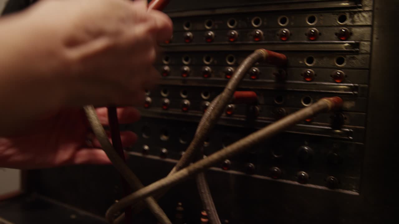 cerca de las manos estresadas cambiando los cables enredados de la central telefónica