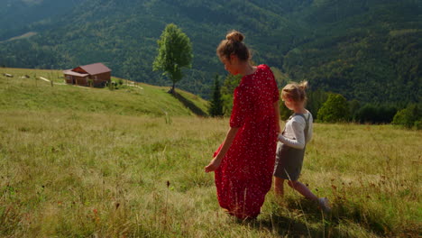 Family-walk-mother-daughter-on-mountain-slope.-Mom-with-child-summer-stroll.