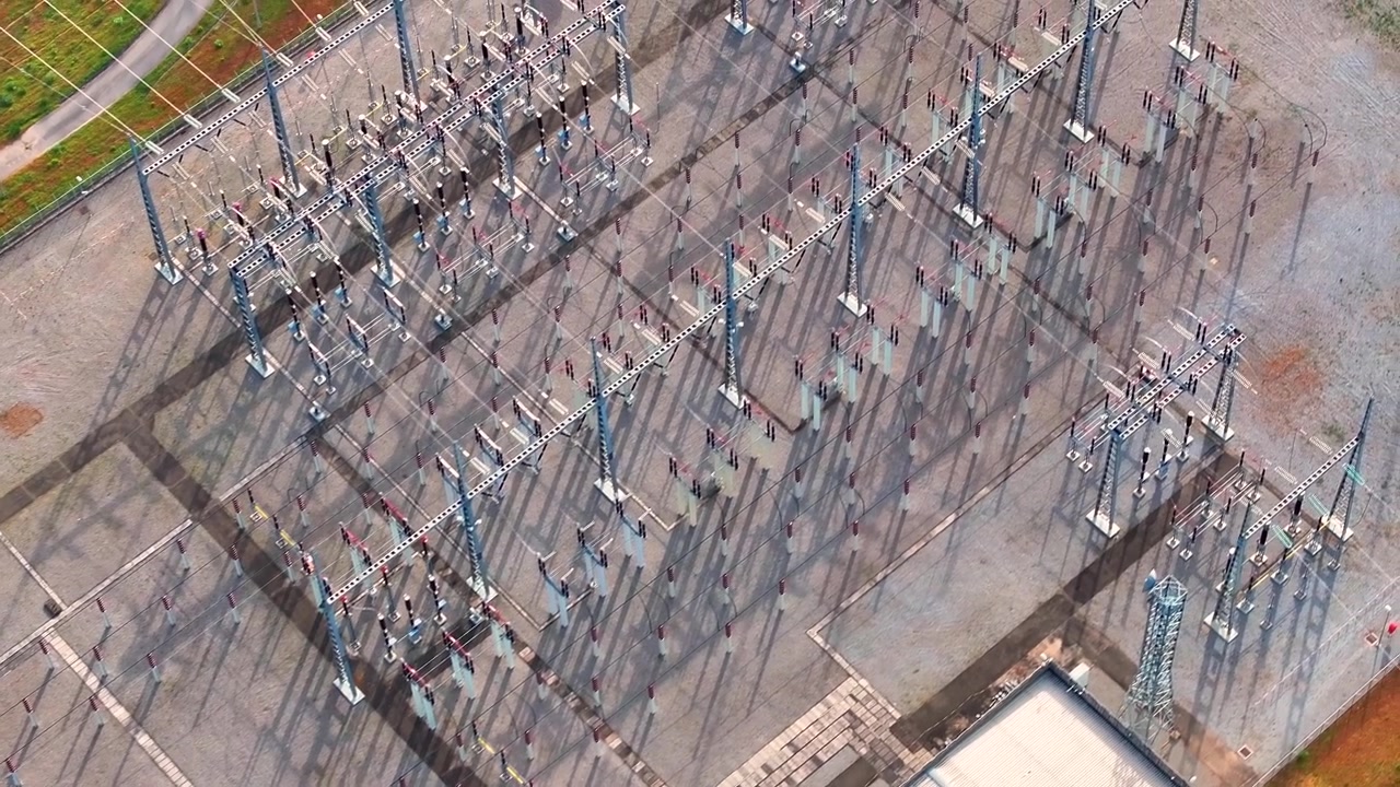 High voltage electrical substation displayed from overhead view. Equipment structures arranged for energy transmission and distribution.