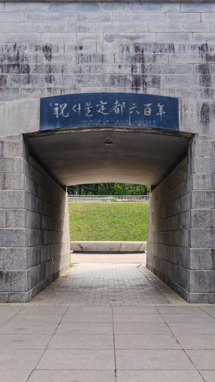 Il passaggio del tunnel in pietra conduce alla Piazza della Capsula del Tempo del Millennio di Seoul, nel villaggio Namsangol Hanok, sepolta nel 1994 per celebrare il 600° anniversario di Seoul come capitale della Corea del Sud