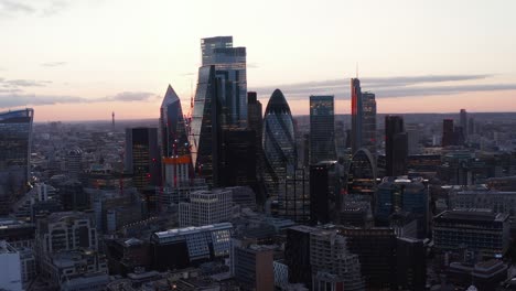 city business hub. modern glass covered tall iconic buildings in evening light after sunset. london, uk