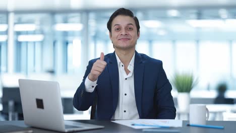 hombre de negocios indio feliz haciendo pulgares hacia arriba
