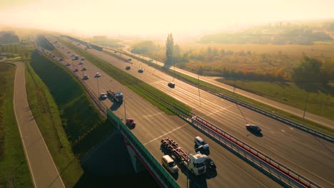 Beautiful-top-side-view-to-the-cars-driving-on-multi-level-highway-on-the-sunny-evening-in-Warsaw-Picturesque-aerial-panorama-of-the-road-traffic-and-sunset-city