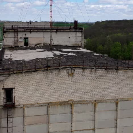 ruined large building of a factory on green nature background. old industrial plant with abandoned building. abandoned factory