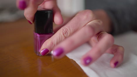 mujer vuelve a enroscar la tapa del esmalte de uñas en el recipiente