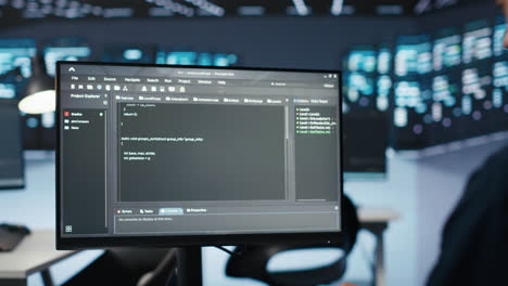 administrador ejecutando script de codificación en la pantalla de la computadora en un centro de datos de alta tecnología,