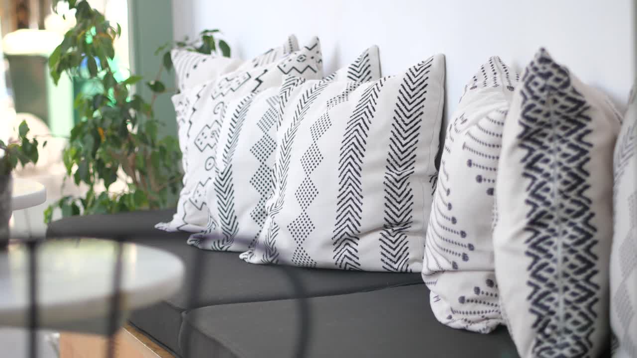 cerca de almohadas con patrones en blanco y negro en un sofá