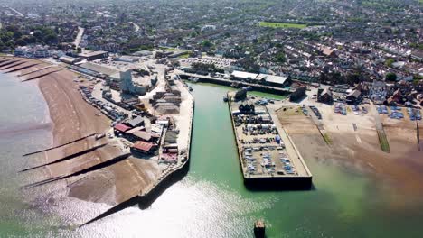 una vista aérea de dolly hacia atrás del puerto de whitstable, con un mar en calma